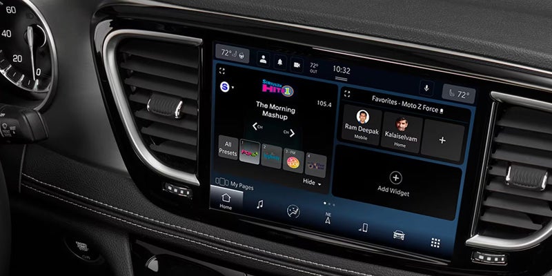A car's dashboard with a large infotainment screen displaying radio, favorites, and navigation.