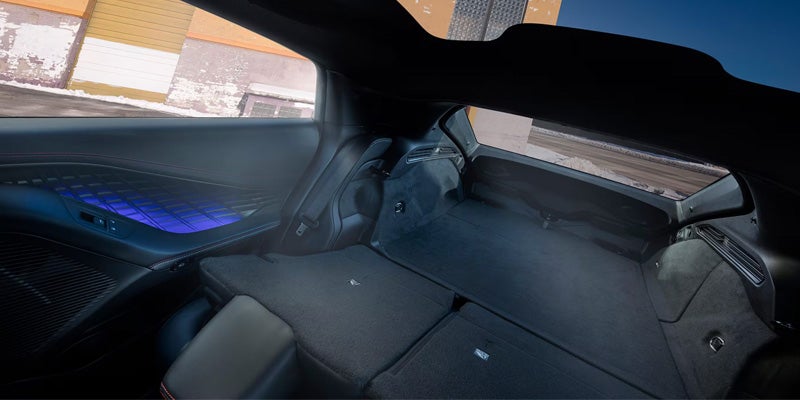 The rear cargo area of a dark-colored car with the back seats folded down provides a long, flat storage space.