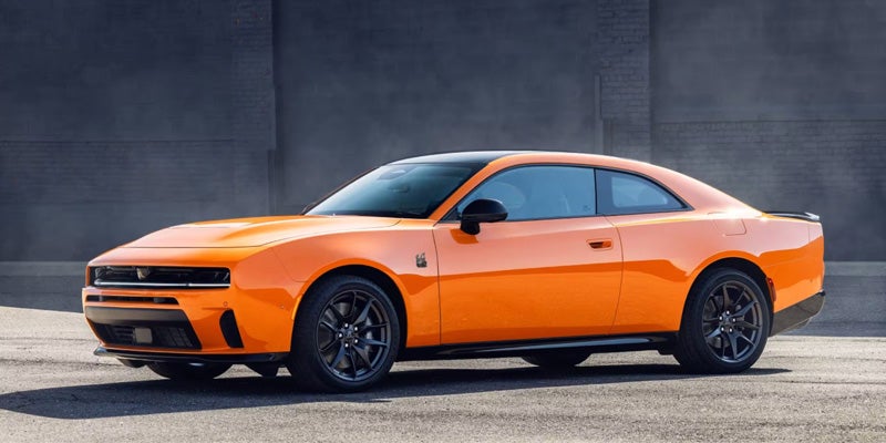 Orange Dodge Charger Daytona SRT Banshee parked with a dark grey background.