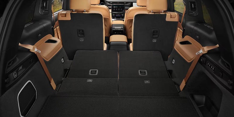 The trunk of a car with the third-row seats folded flat and the second-row seats upright.