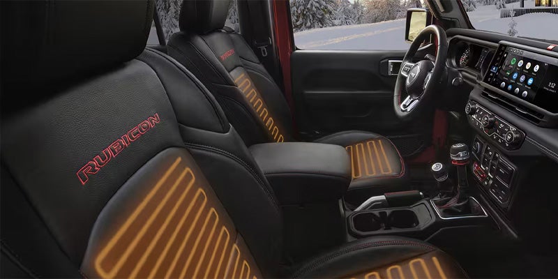 Interior of a Jeep with black and red Rubicon seats, glowing orange to show heating elements.