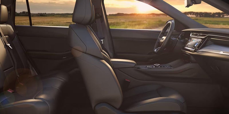 View of a car's interior from the backseat, showing black leather seats, dashboard, and a digital display.
