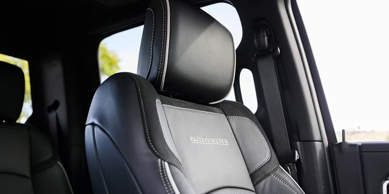 Front passenger seat of a car, black with gray accents and the word "LARAMIE" embroidered on it.