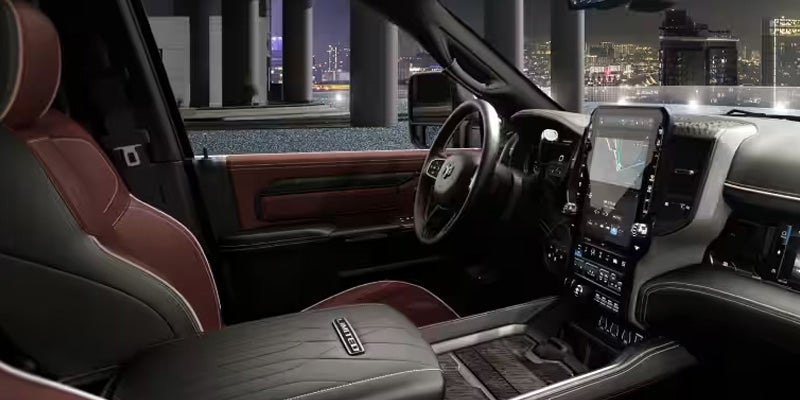 Luxurious dark red and black leather car interior with a large vertical screen, seen from the passenger side.