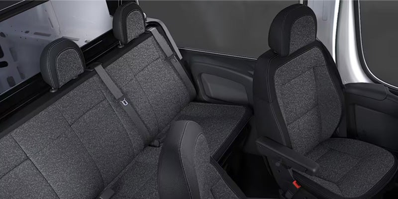 Interior shot of a van showing black seats with light gray fabric inserts, including folded-down rear seats.